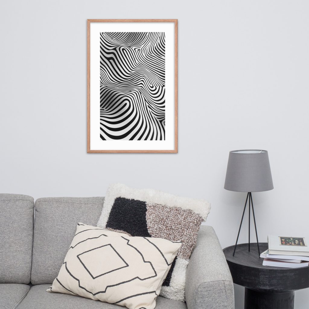 A living room with a grey couch, black side table, and an abstract black and white framed artwork on the wall.