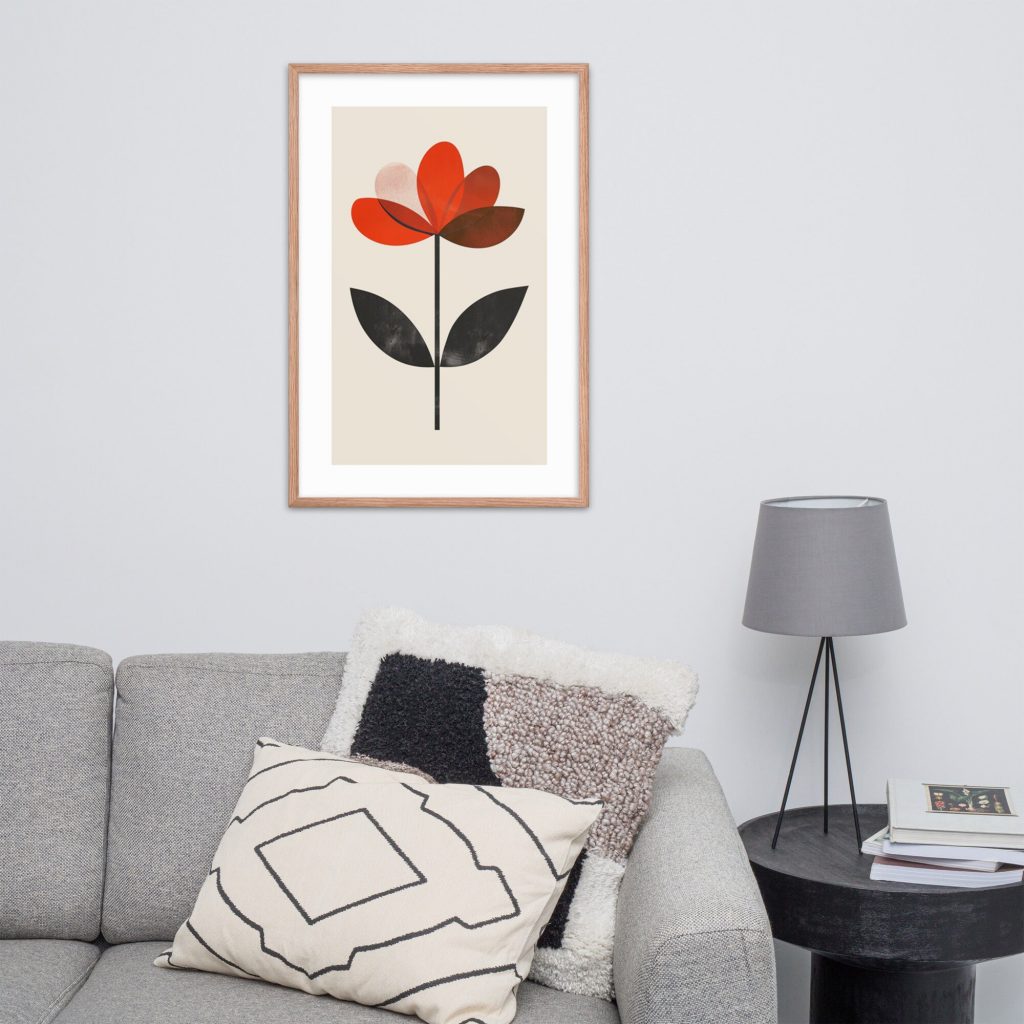 Framed floral artwork hanging above a gray couch with cushions and a side table with a lamp.