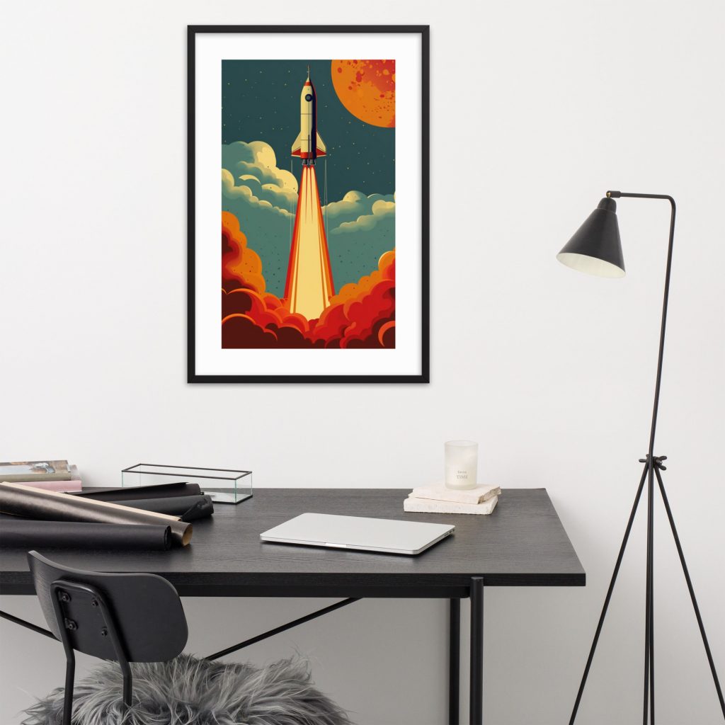 A framed rocket launch artwork hanging above a modern desk setup.