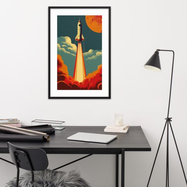 A framed rocket launch artwork hanging above a modern desk setup.