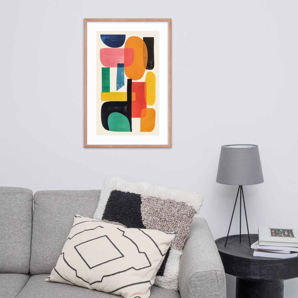 Abstract artwork in wooden frame above a grey couch with pillows and black side table.