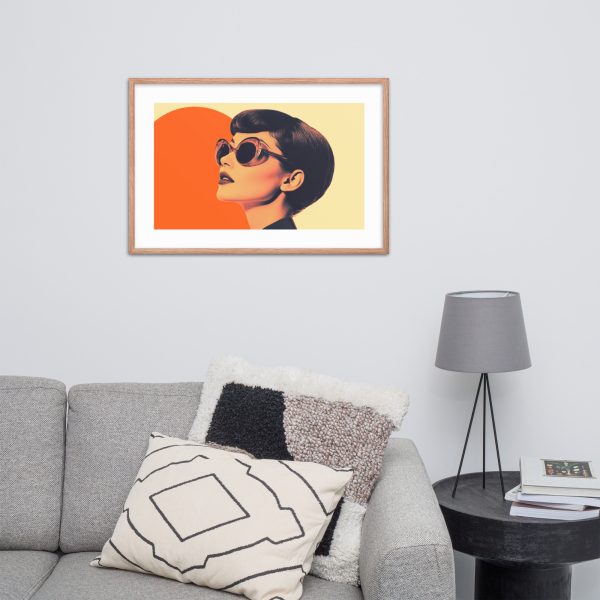 A framed pop art print of a woman with glasses hangs above a modern grey sofa with patterned cushions.