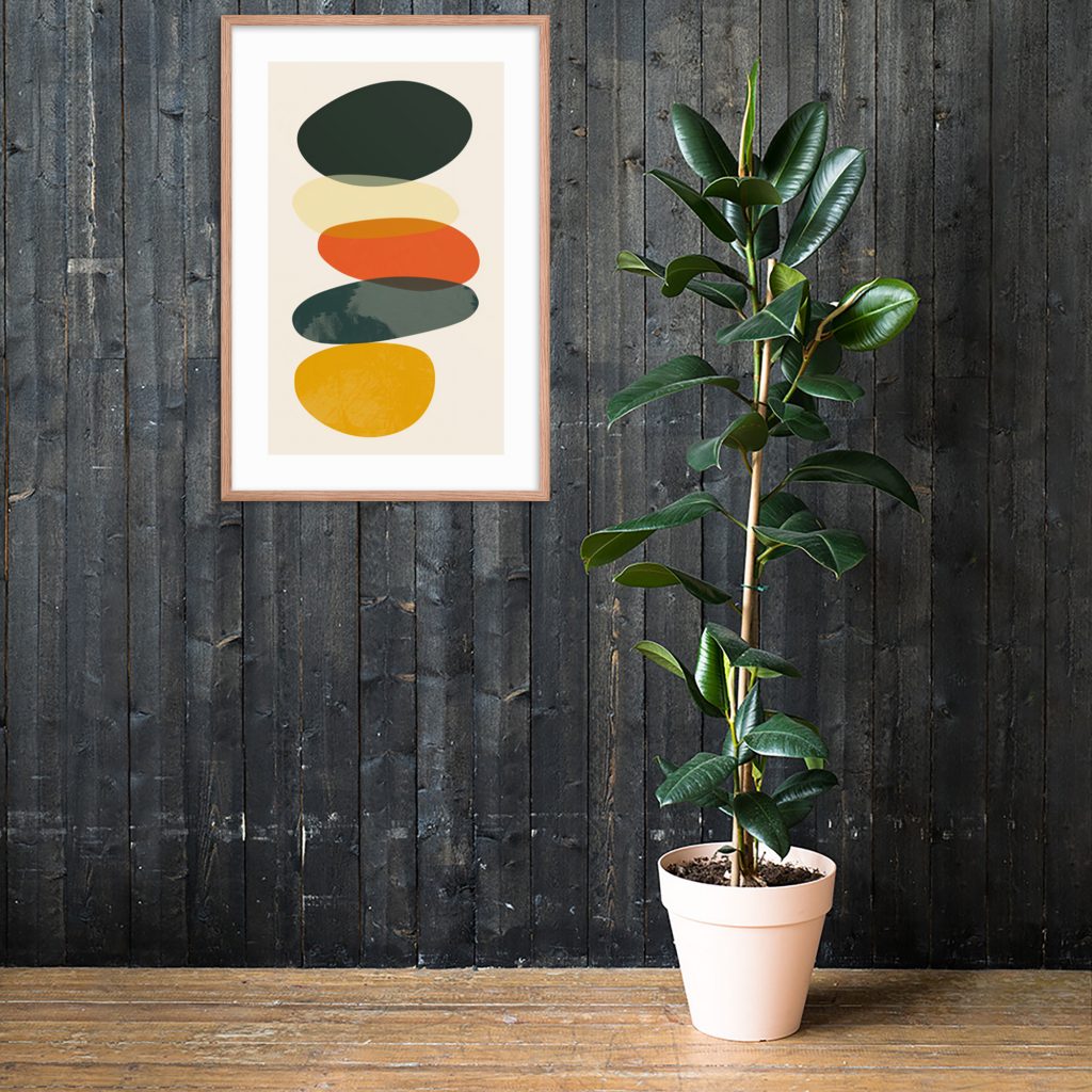 Framed abstract art with potted plant against dark wooden wall.